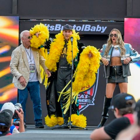 Driver Josh Bilicki, center, with the wild feathery outfit, has wrestling legend Ric Flair help with this walk out and also Flair's daughter Charlotte, who is also a professional wrestler.