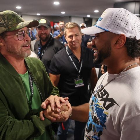 Brad Pitt (left) talks with Super Bowl winning quarterback Russell Wilson before the driver's meeting. Wilson was a guest of NBA legend Michael Jordan, co-owner of 23XI Racing.