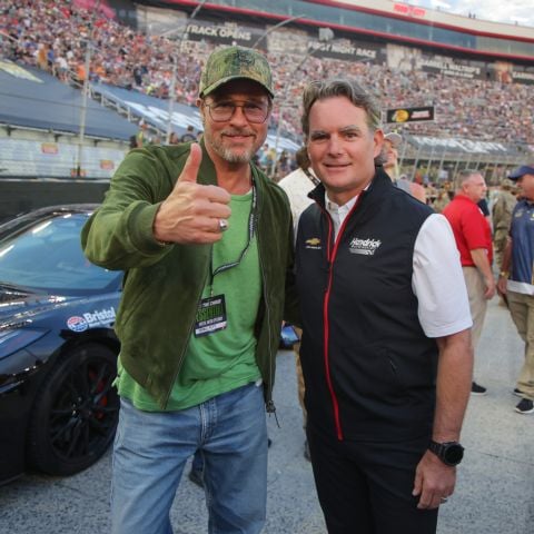 Brad Pitt (left) and NASCAR legend Jeff Gordon share a moment before jumping into the BMS Corvette pace car for a couple of ceremonial laps.