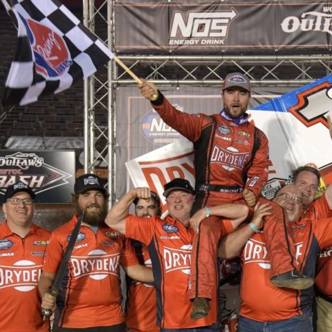 Logan Schuchart waves the checkered flag and is hoisted up by his team after winning Friday's World of Outlaws Bristol Bash.