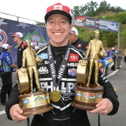 Top Fuel winner Justin Ashley proudly holds both NHRA Wally trophies Sunday at Bristol Dragway after sweeping a pair of national event titles over the weekend.