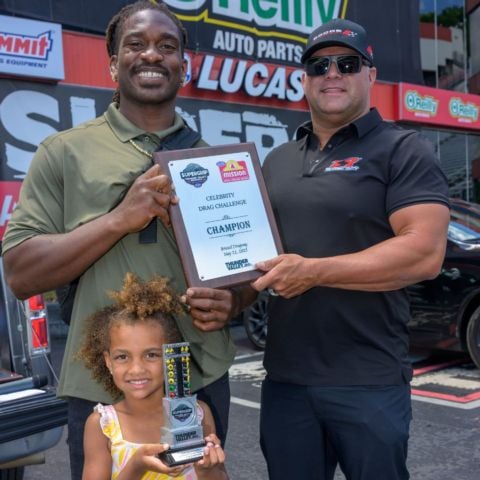 Winner AJ Johnson receives the plaque and trophy from four-time NHRA Funny Car champ Matt Hagan.